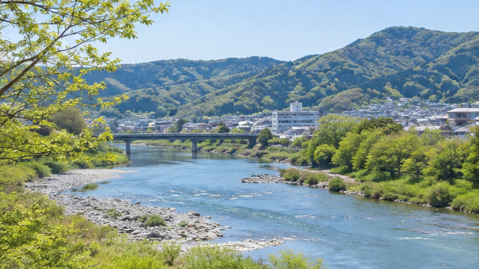 可児市の川沿いと山並みを望む春の景色