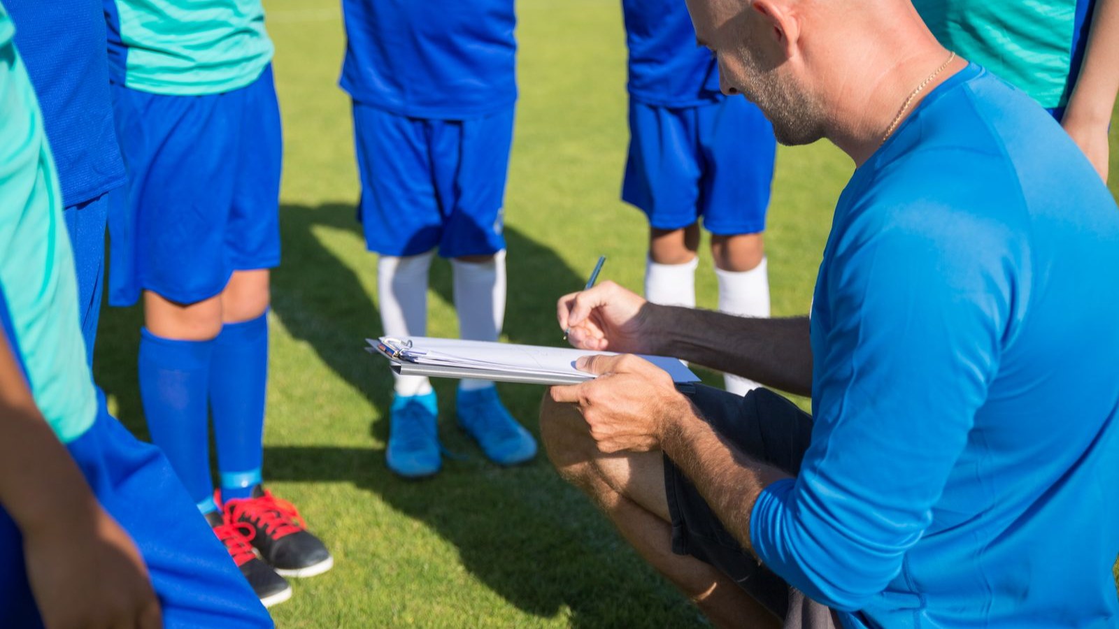 コーチと一緒にサッカーの練習をする子どもたち