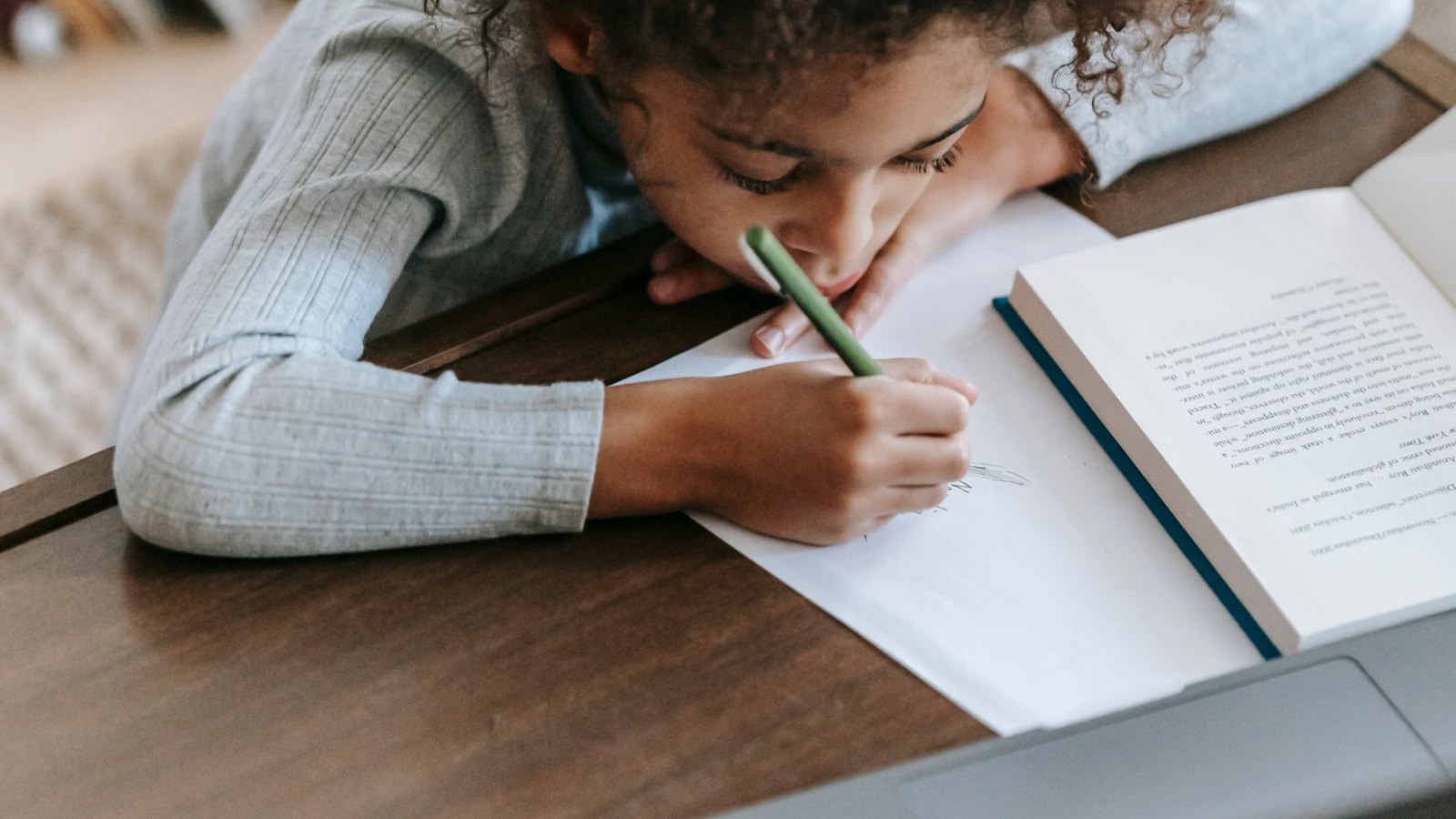 ノートに書きながらパソコンで学ぶ子ども