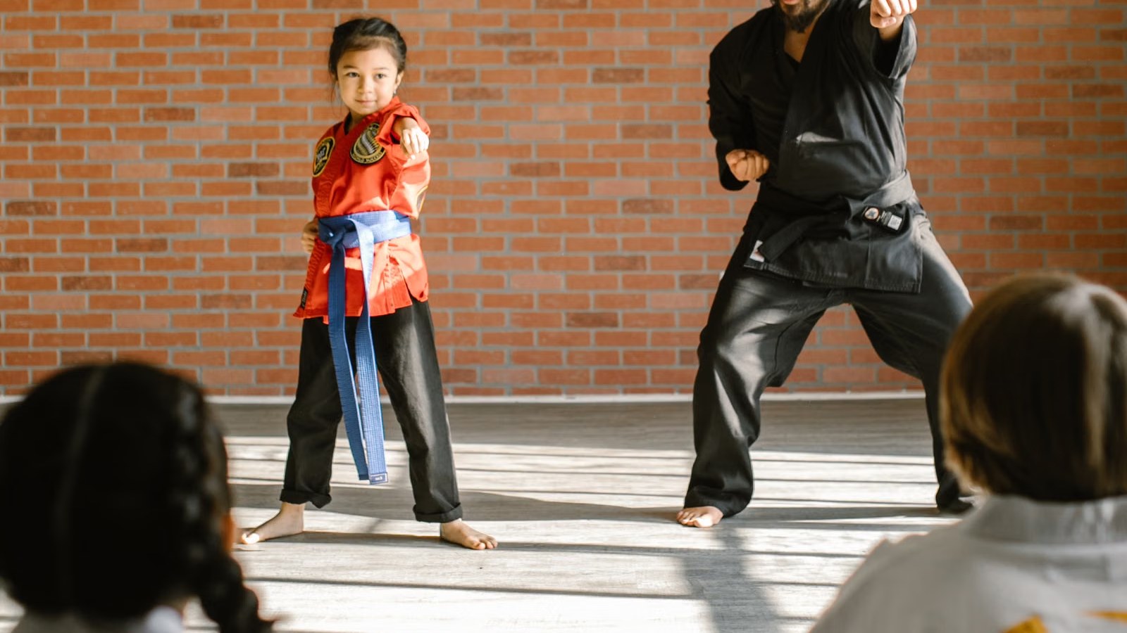 道場で子どもたちが先生の稽古を見て学ぶ様子