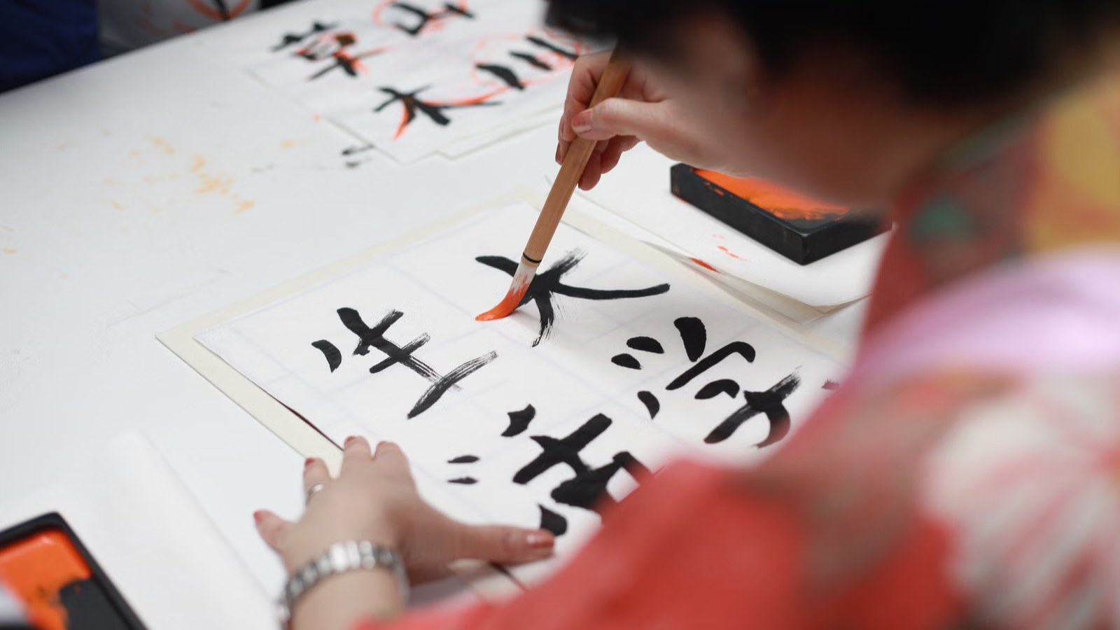 筆で文字を書く子どもの手元