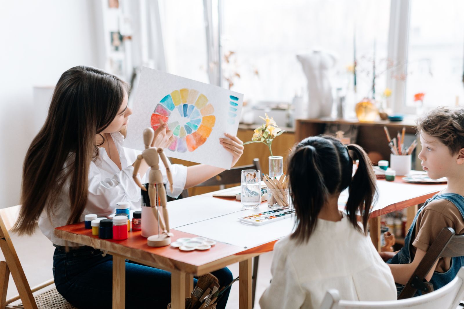 美術のワークショップで先生と一緒に色を学ぶ子どもたち