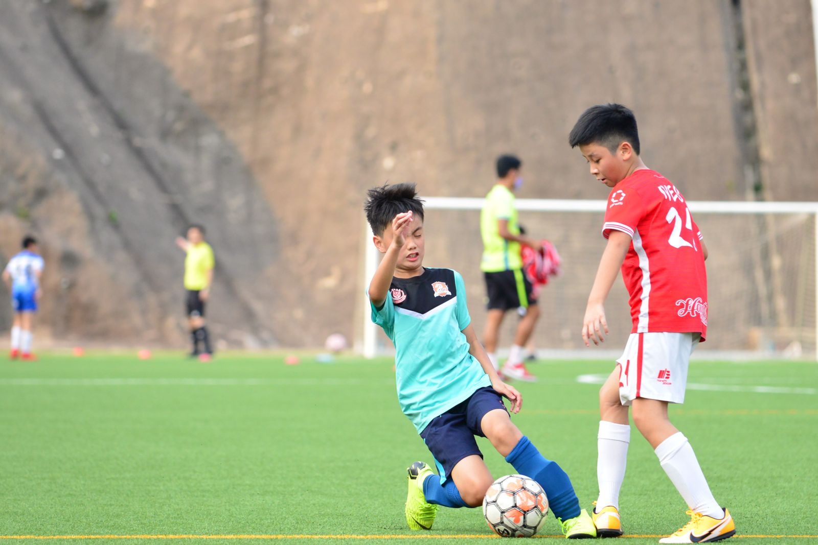 屋外でサッカーを楽しむ子どもたち