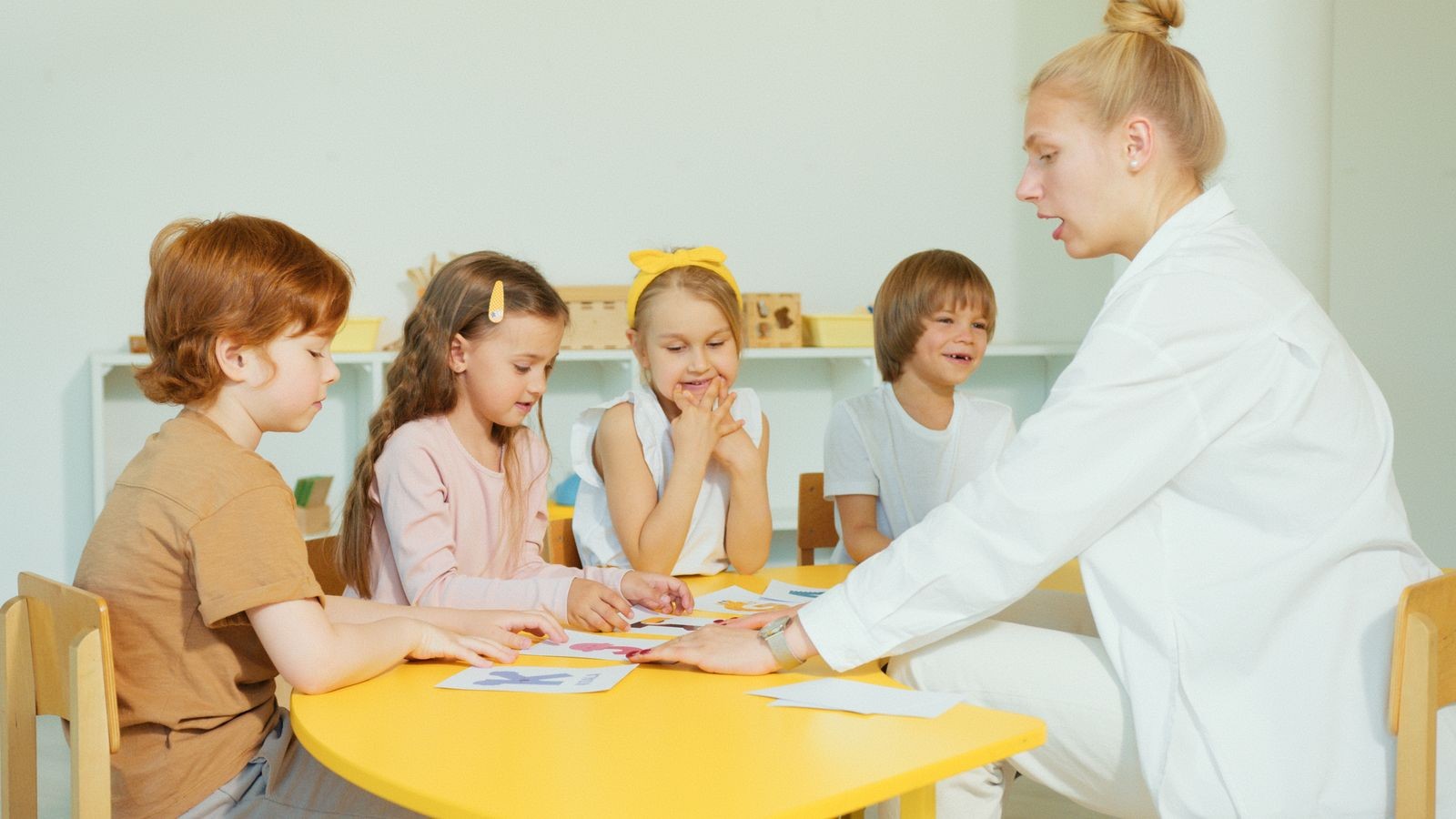 先生と一緒に英語のカードで学ぶ幼い子どもたち