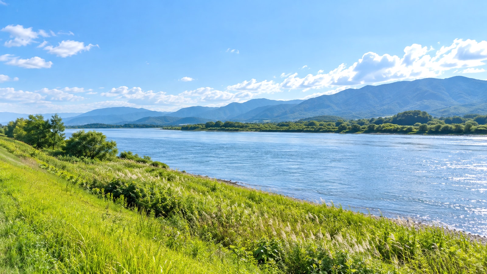 木曽川の堤防と青空を望む桑名市周辺の明るい景色