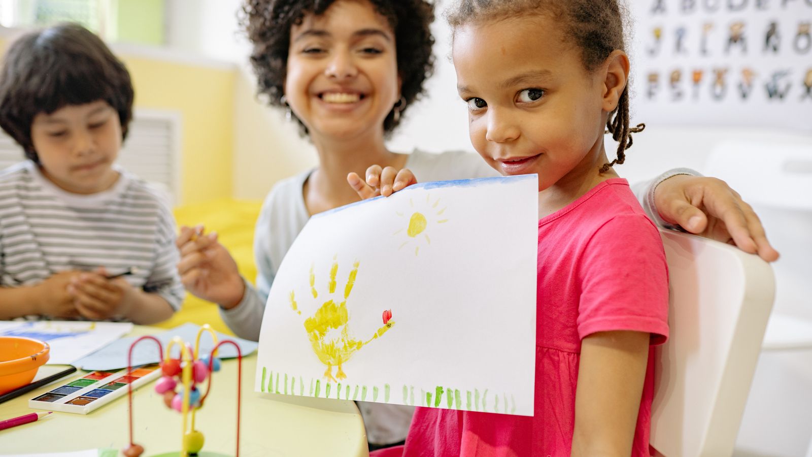手形の絵を先生と見せる子どもたち