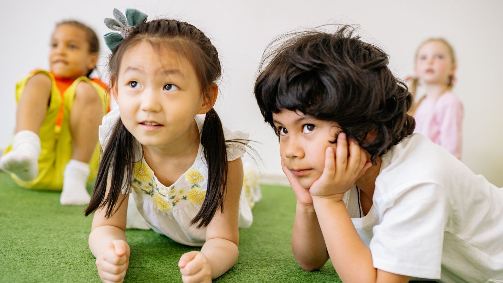 芝生のマットに寝そべる子どもたち