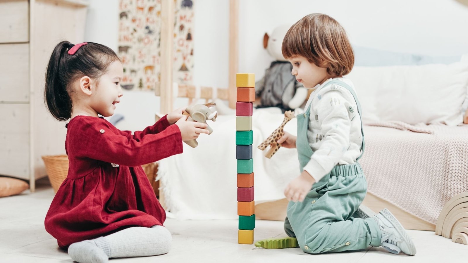木のおもちゃで遊ぶ二人の子ども