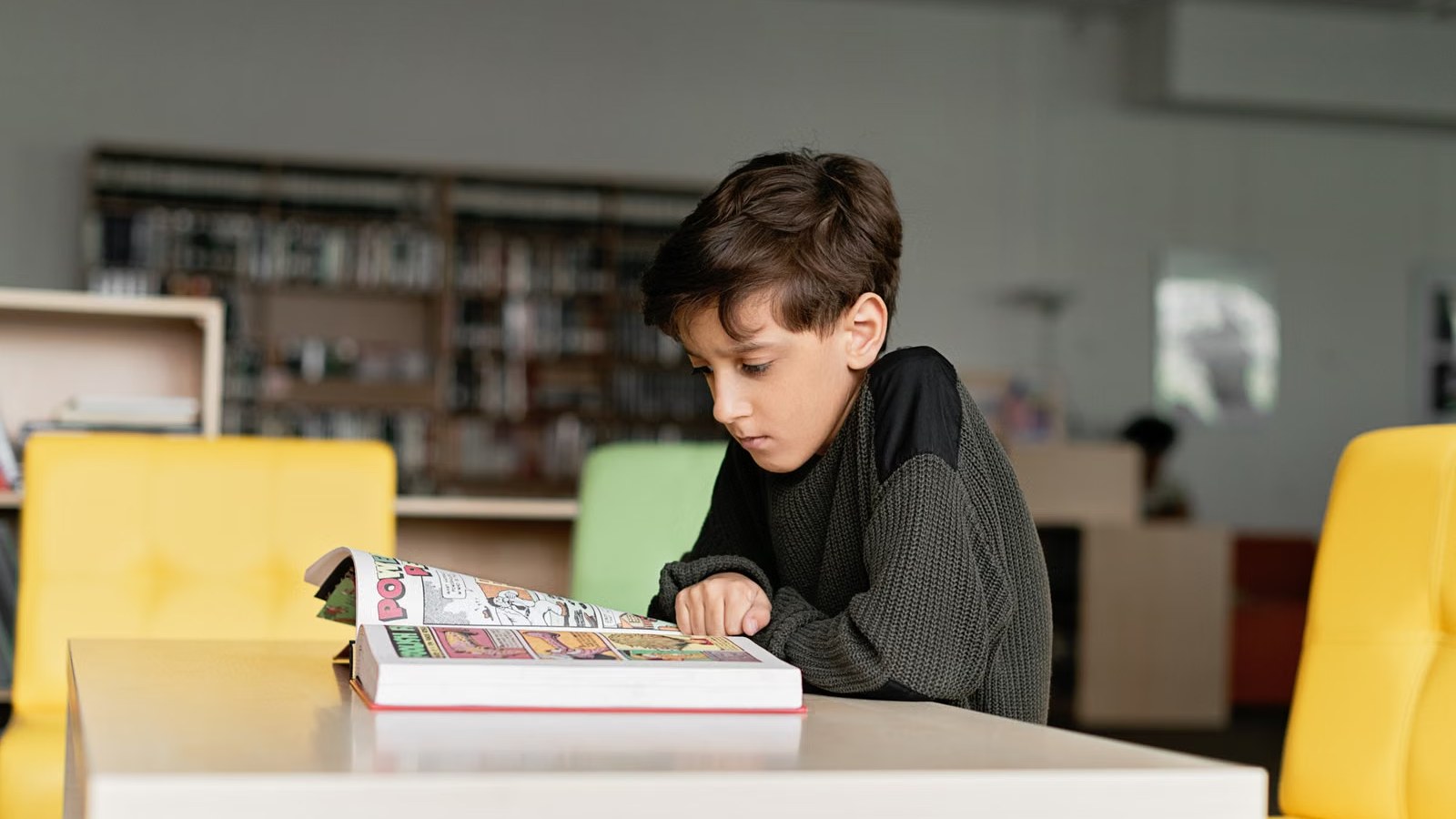 図書館の机で本を読む子ども