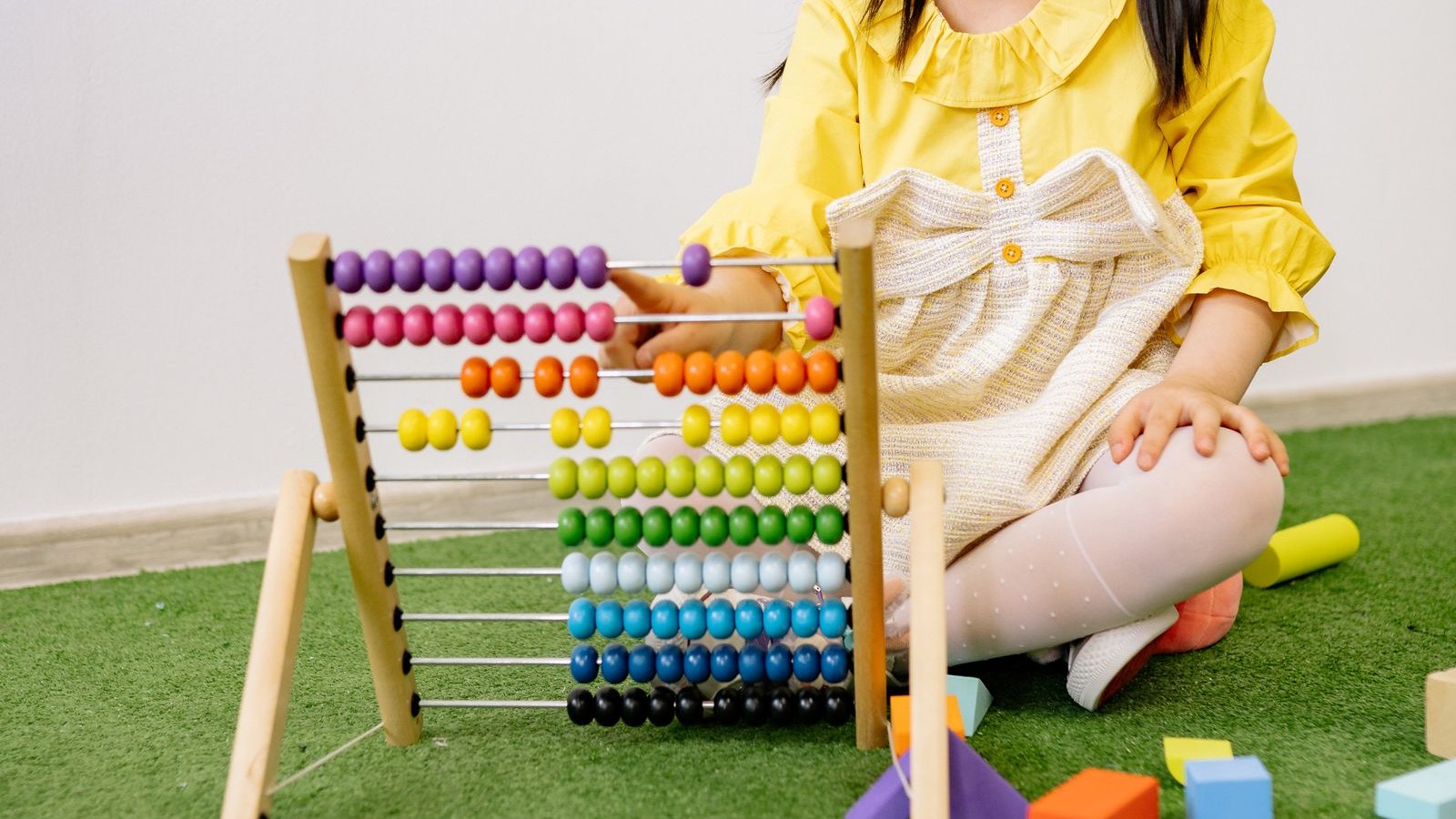 カラフルなそろばんで算数を学ぶ女の子