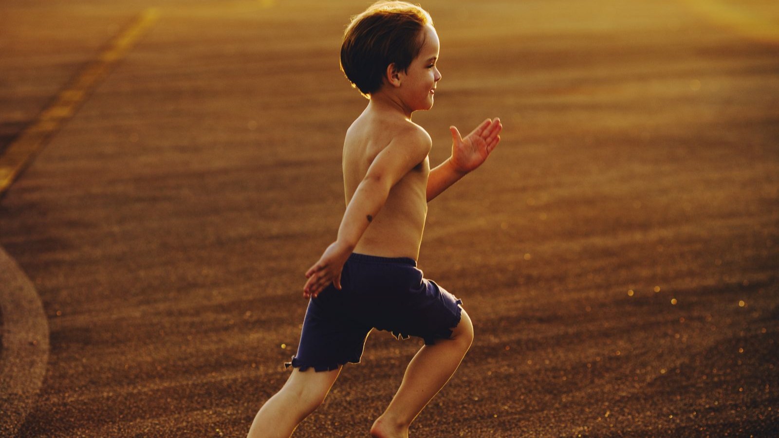 夕方のトラックを元気に走る男の子