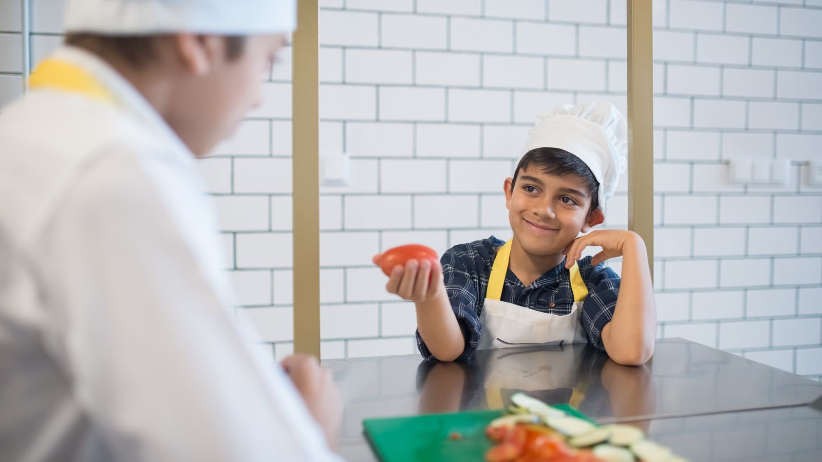 エプロンと帽子で料理を楽しむ男の子