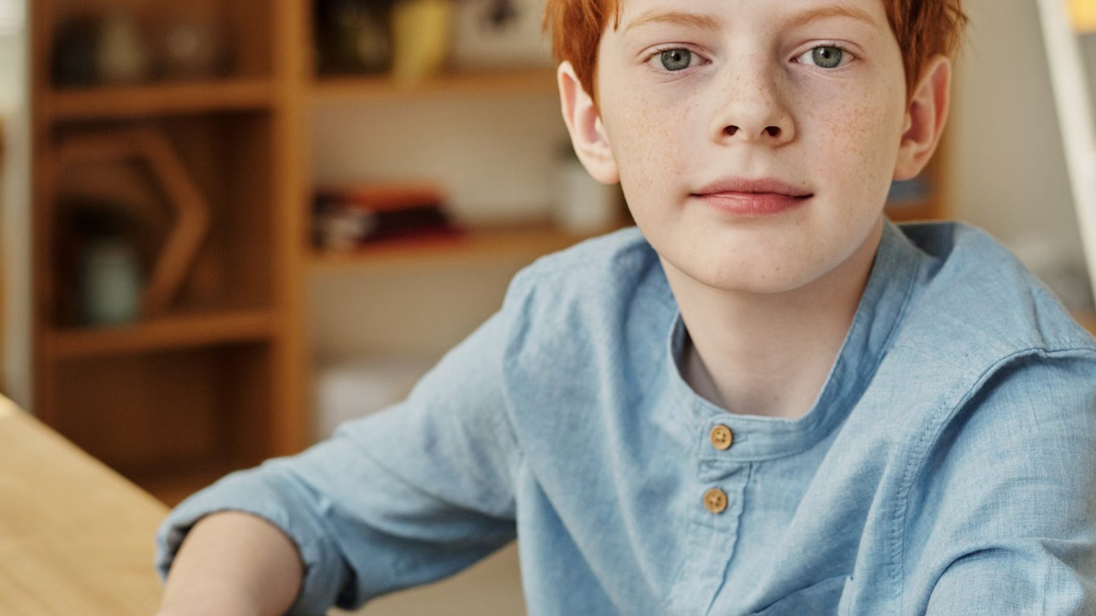 机に座ってこちらを見る男の子