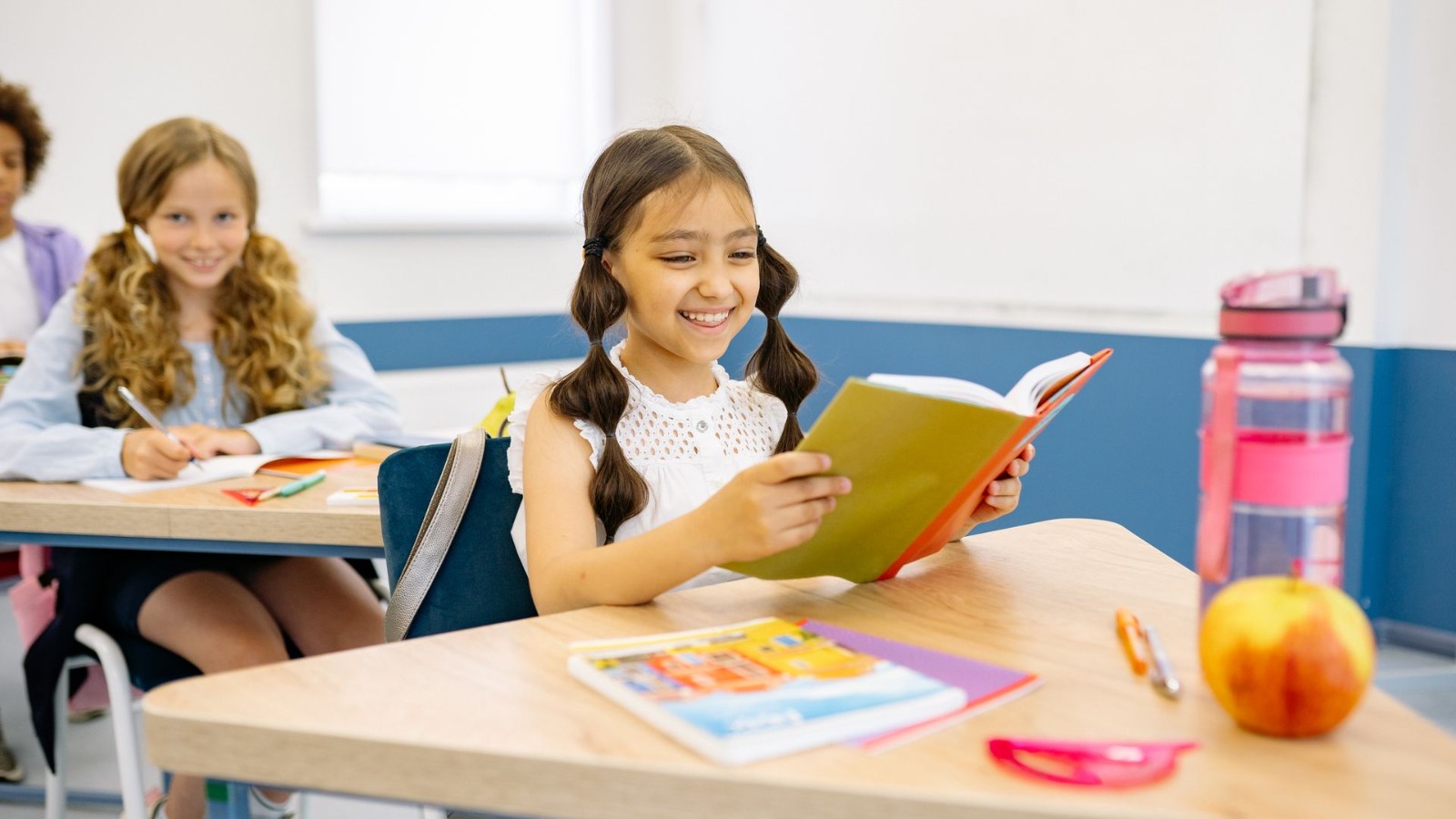 明るい教室で読み書きをする小学生