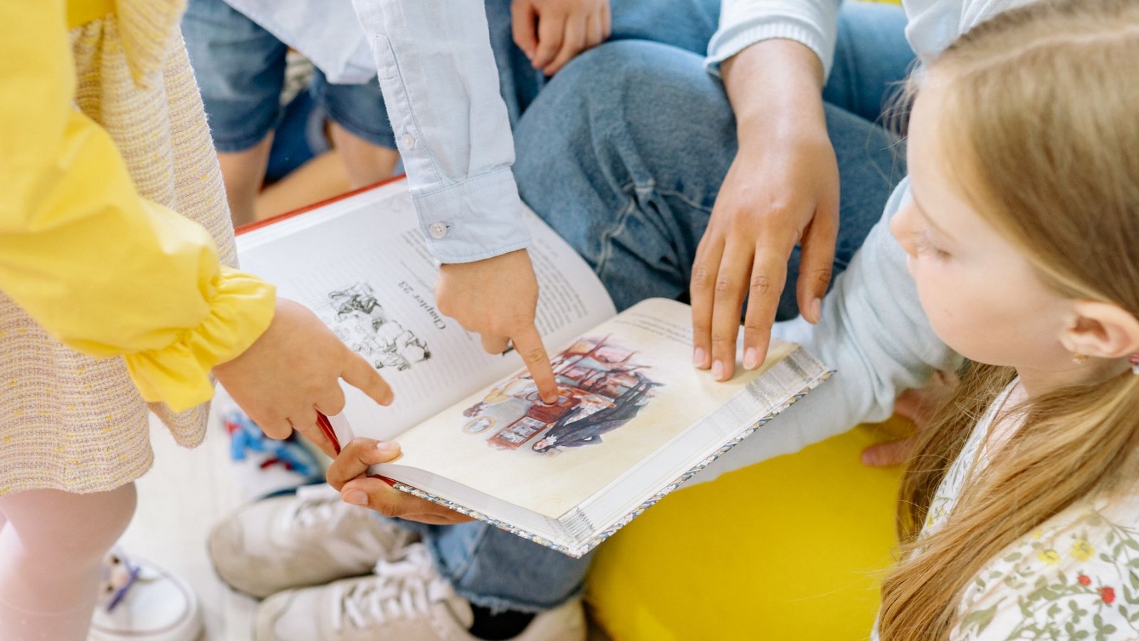 子どもたちが集まって、一冊の本を一緒にのぞき込んでいる様子