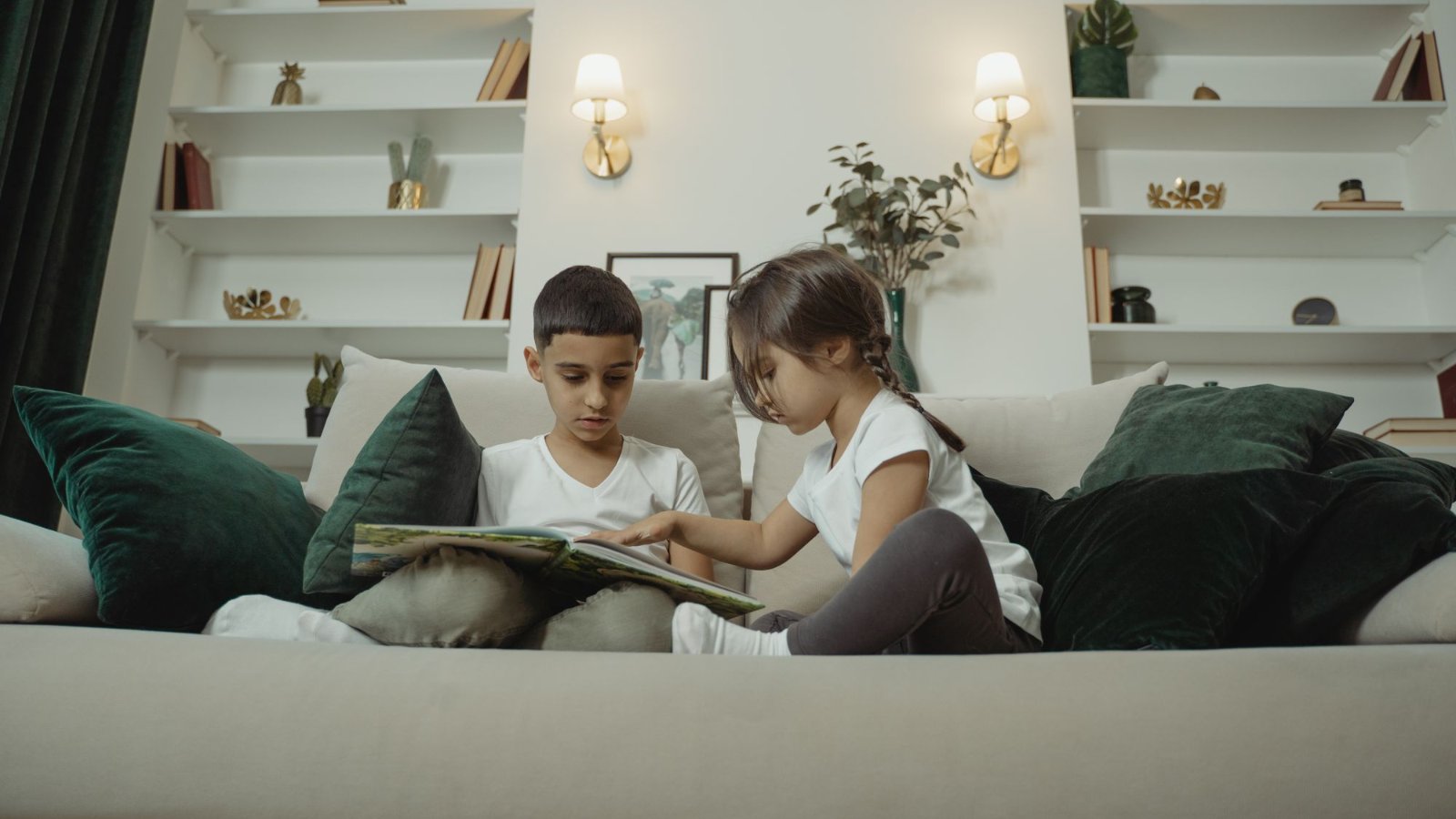 ソファで本を読む二人の子ども