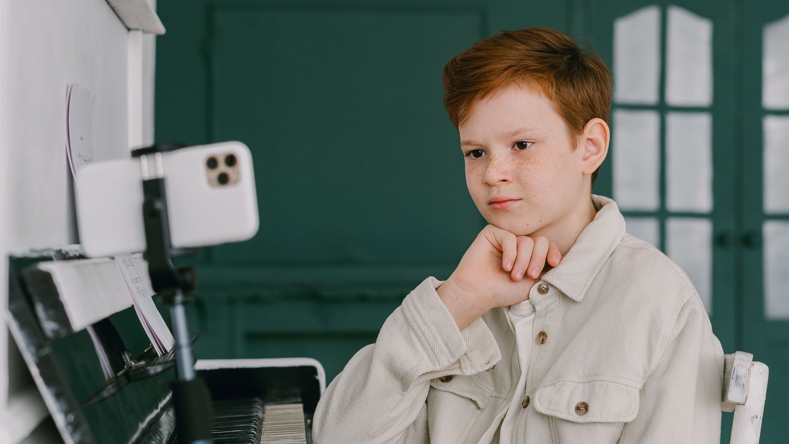 自宅でオンラインのピアノレッスンを受ける男の子