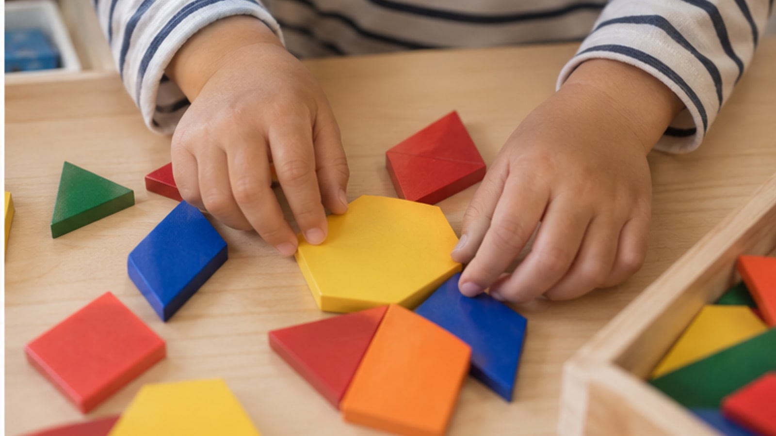 カラフルな図形ブロックで遊ぶ子どもの手元