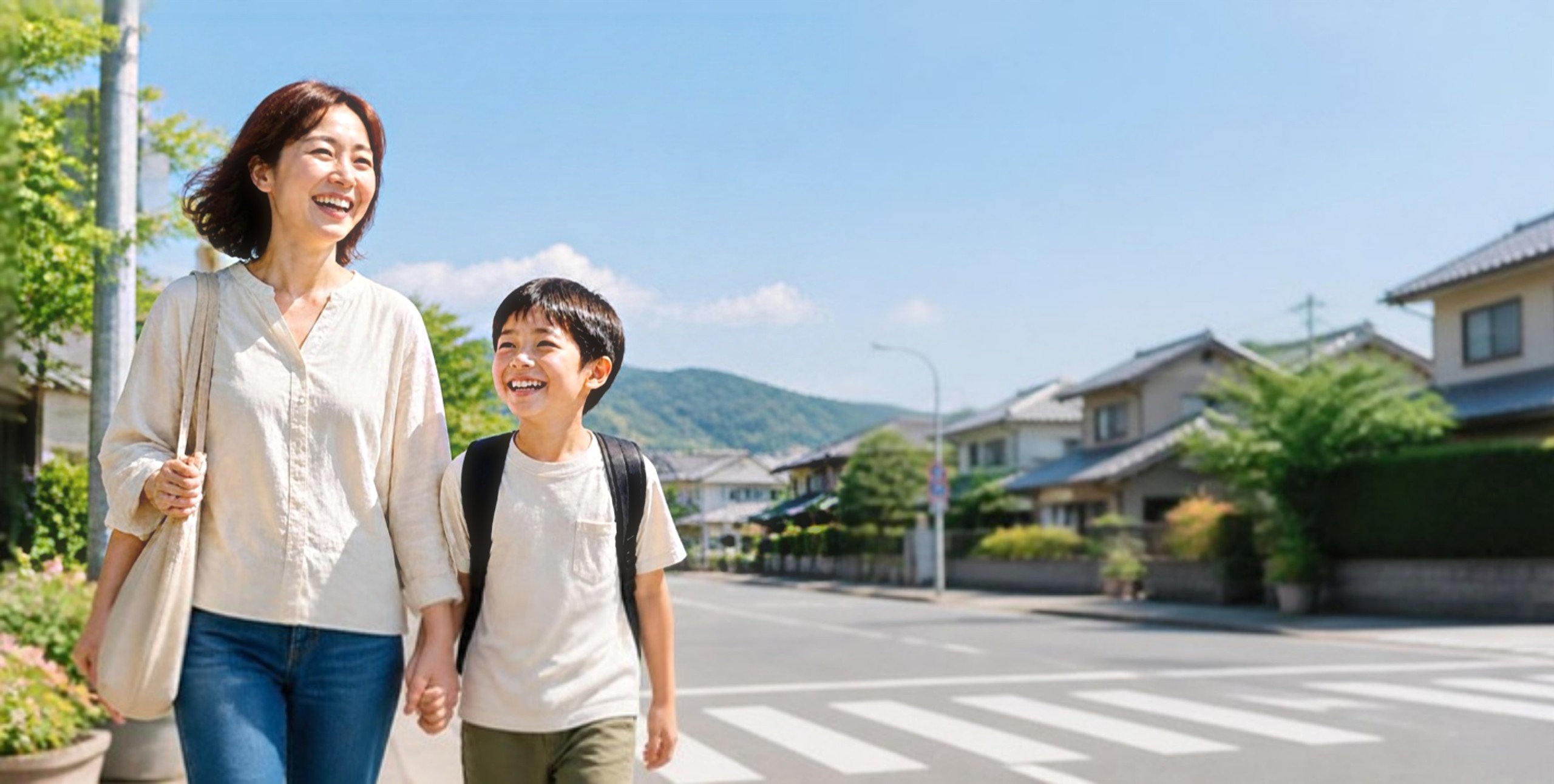 街角を手をつないで笑顔で歩く親子