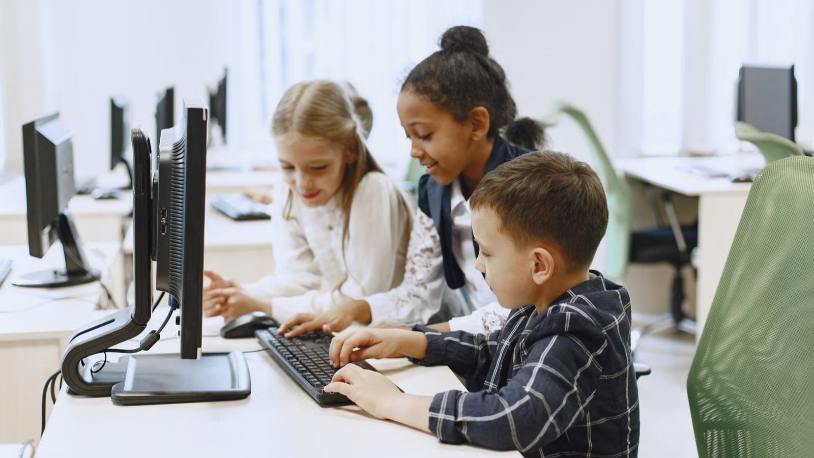 パソコンの前で一緒に学ぶ子どもたち