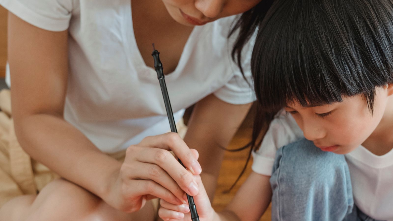 筆を使って絵や文字を描く子どもと大人