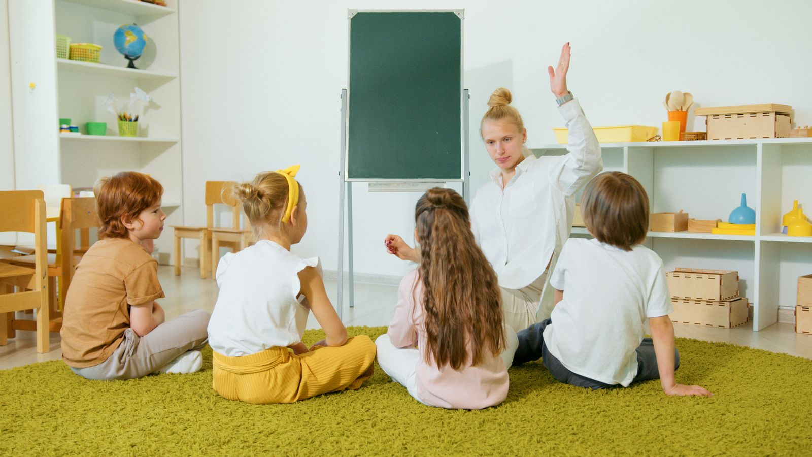 教室で手を挙げる先生と子どもたち