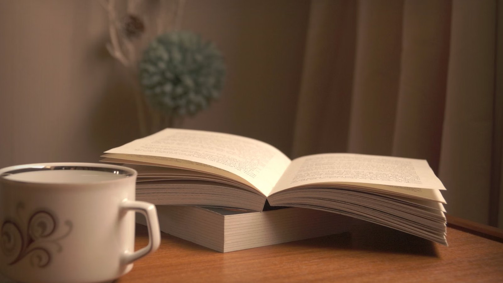 開いた本と、お茶の入ったカップが置かれた机