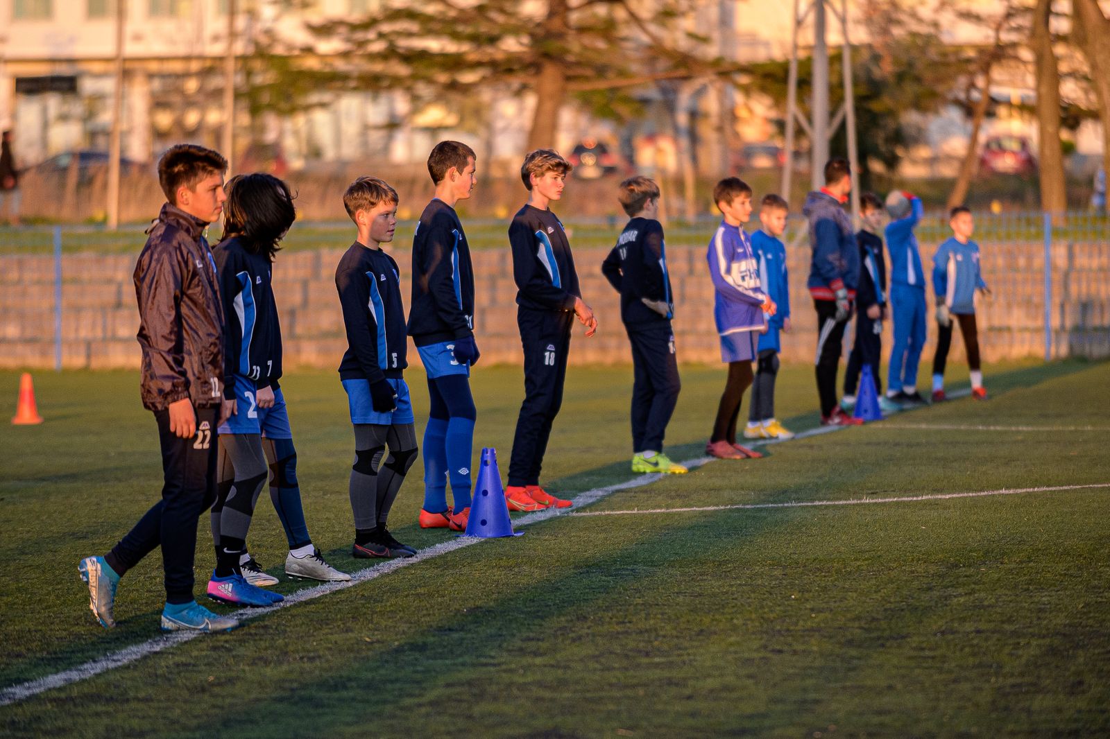 サッカーの練習のためにグラウンドに並ぶ子どもたち