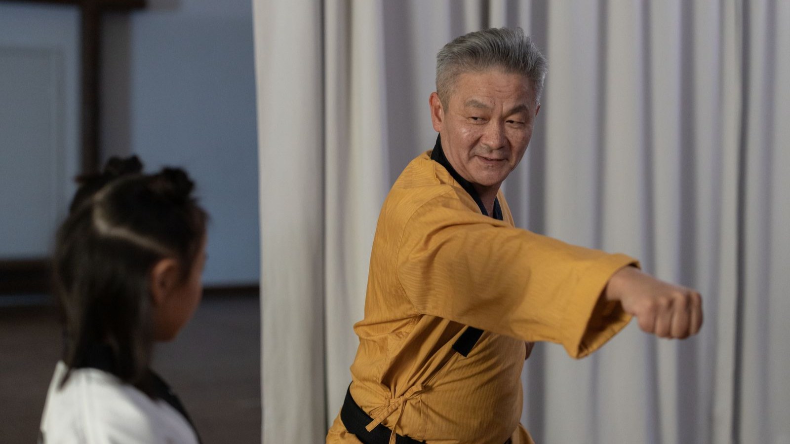 武道の師範から指導を受ける子ども
