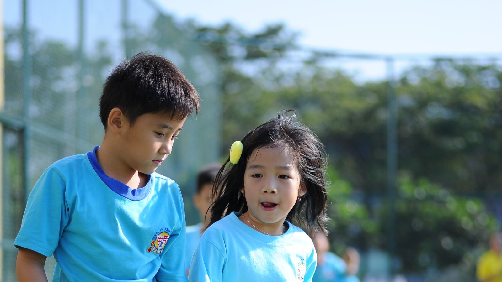 リレーのバトンを持って走る小学生の子どもたち