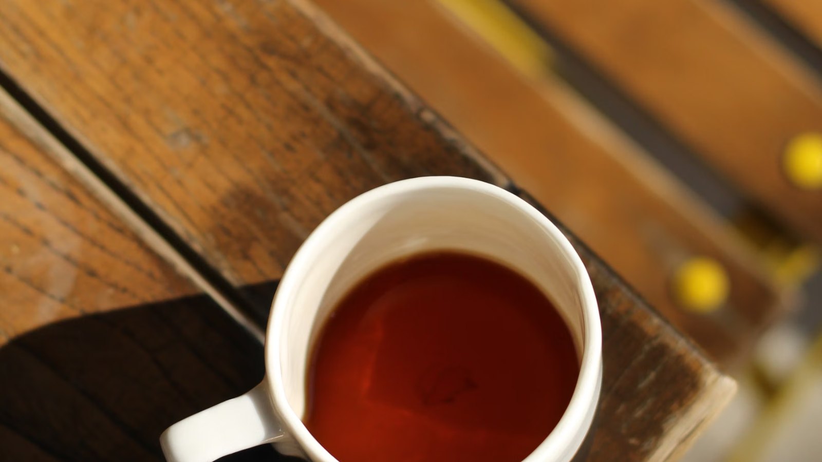 木のテーブルに置かれた紅茶のカップ