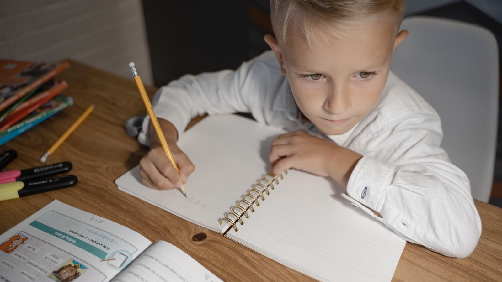 机でノートに書き込む男の子