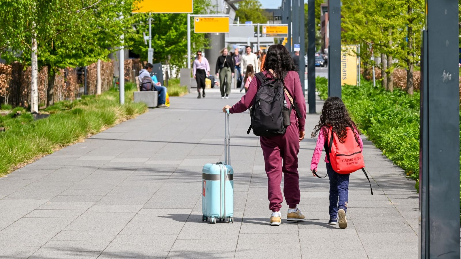 A family with a child walking through an airport with suitcases