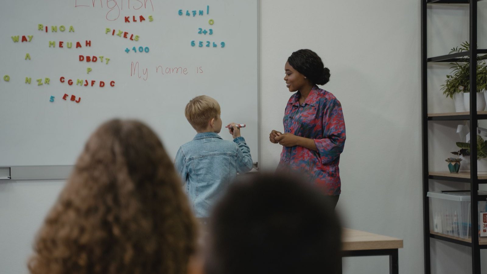 英語の授業で手を挙げる子どもたち