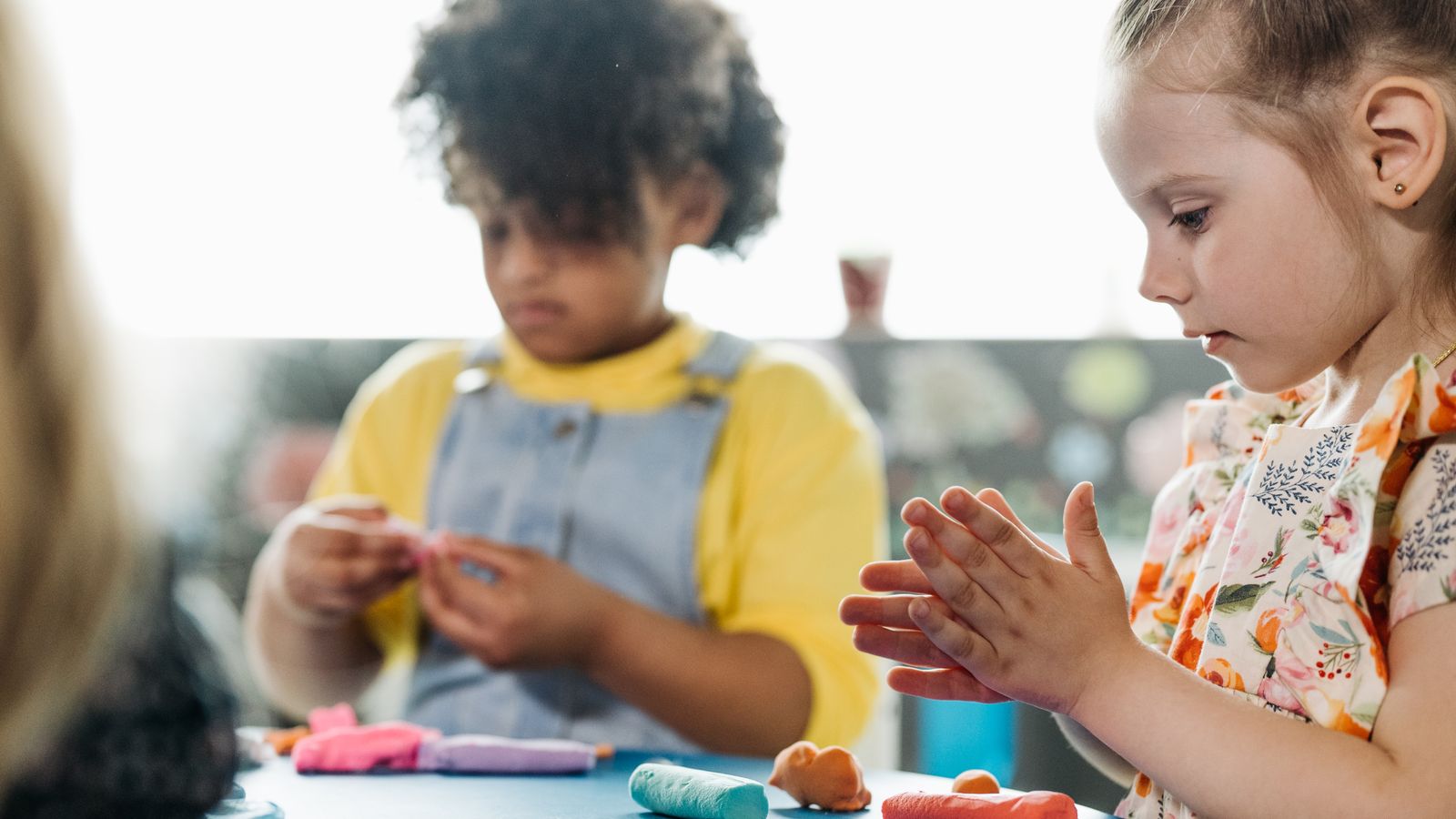 粘土を手に遊ぶ幼児と子ども