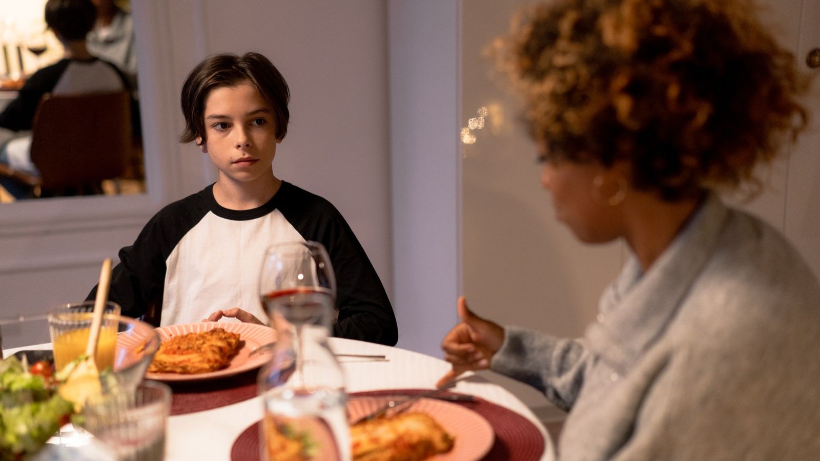 A family sitting around a dinner table with an older child