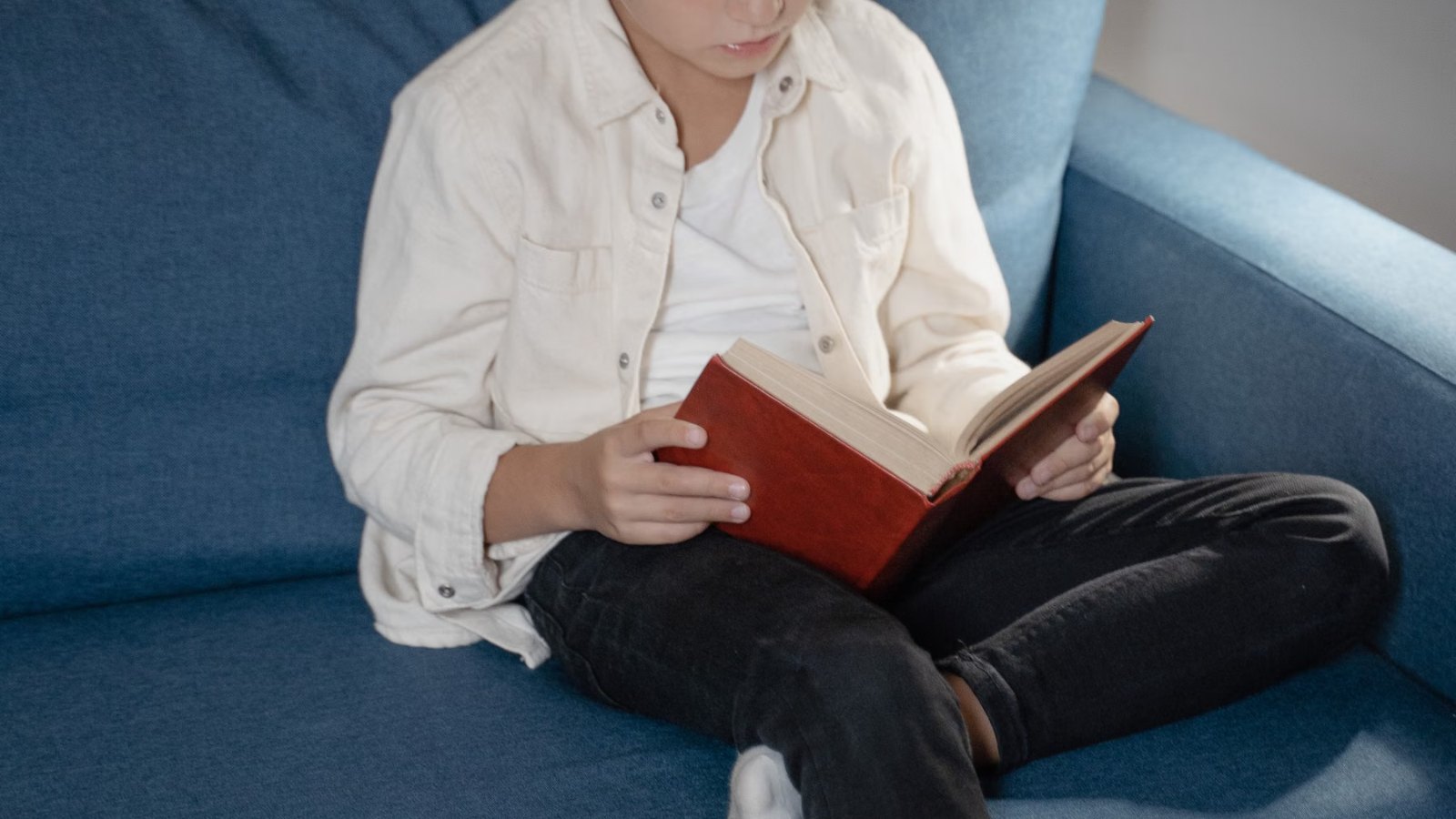 ソファで本を読む男の子