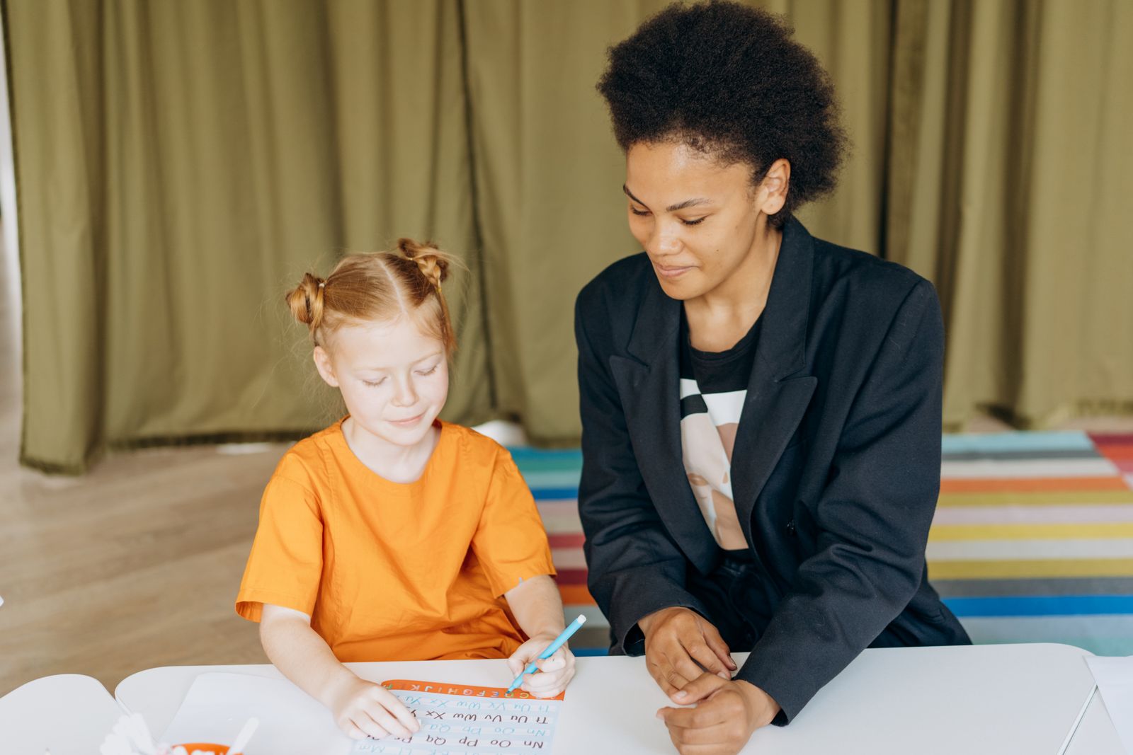 先生と机に向かって英語を学ぶ女の子