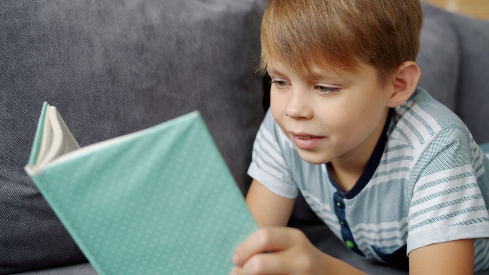 本を読んで笑顔を見せる男の子