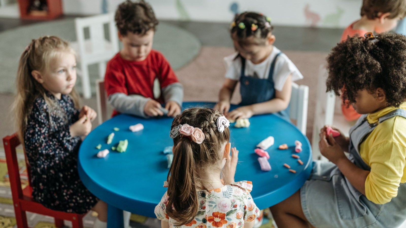 テーブルで粘土遊びをする子どもたち