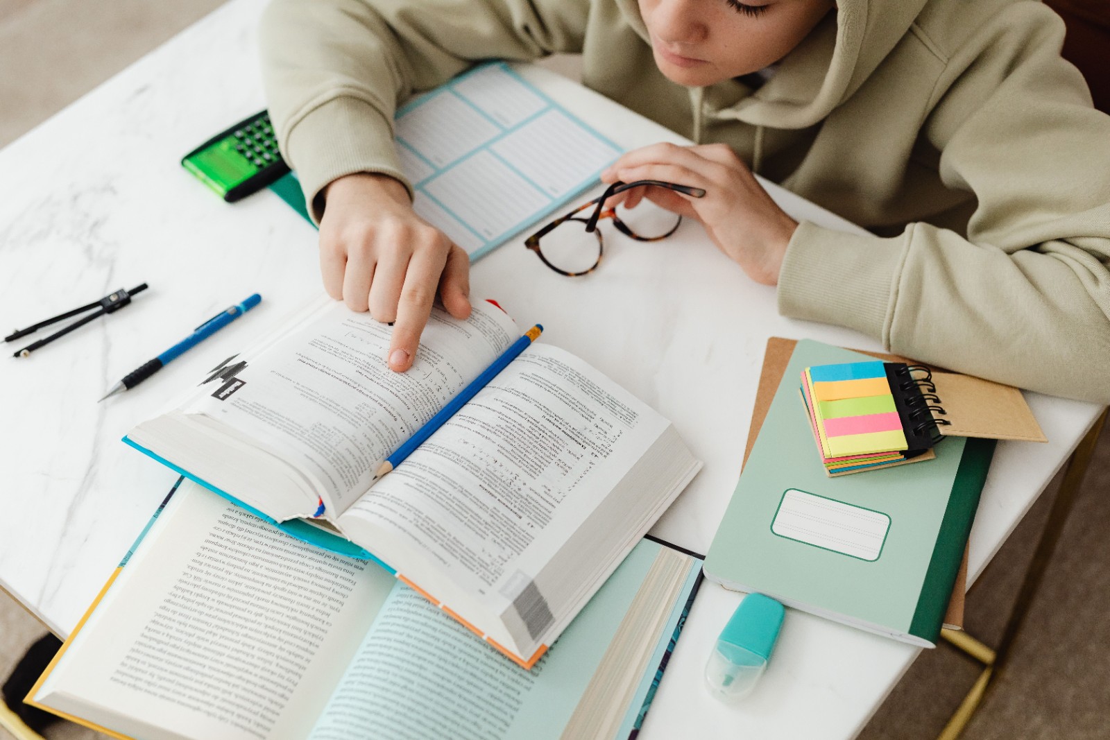 教科書と電卓とノートを広げて勉強する生徒