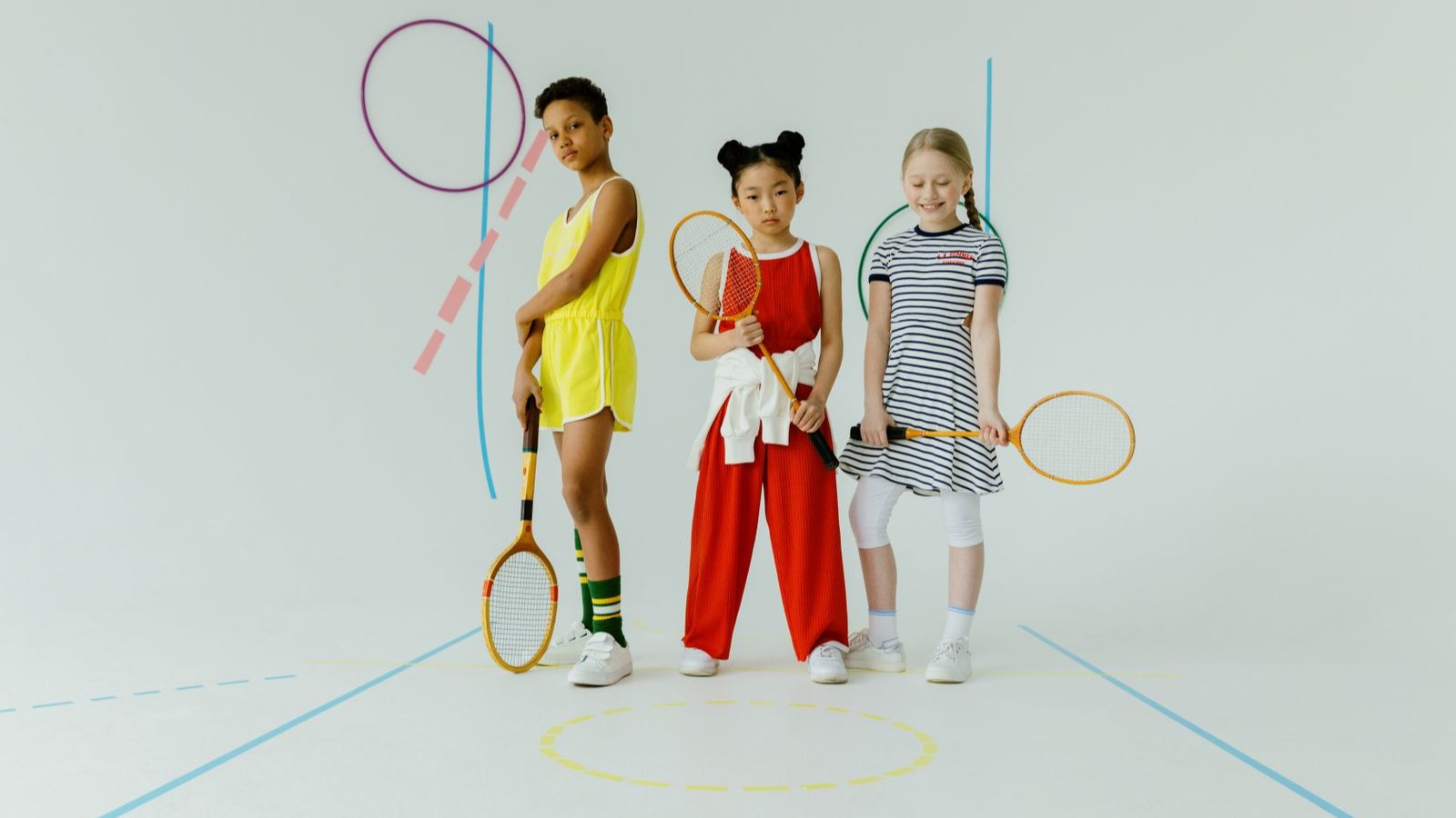 ラケットを持って並ぶ三人の子ども